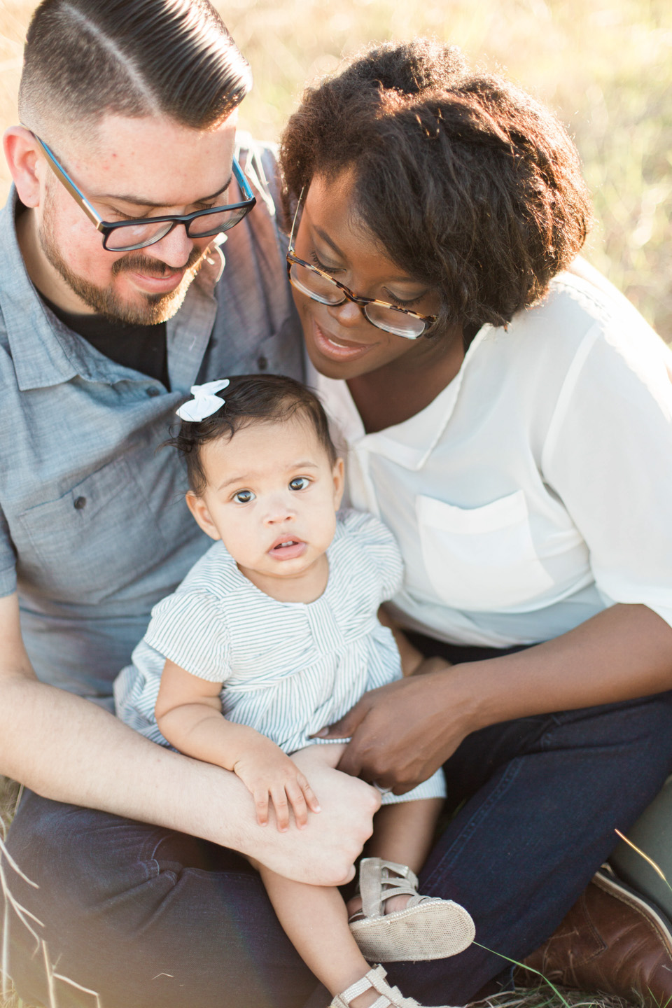 mom and dad with little girl in lap family session