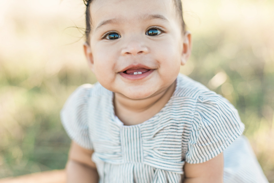 smiling baby girl in family shoot by marie holmes co