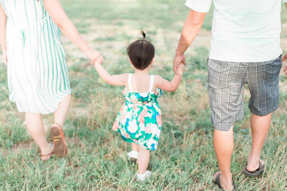 austin-texas-family-photographer-little-girl-walking-with-parents-at-the-park